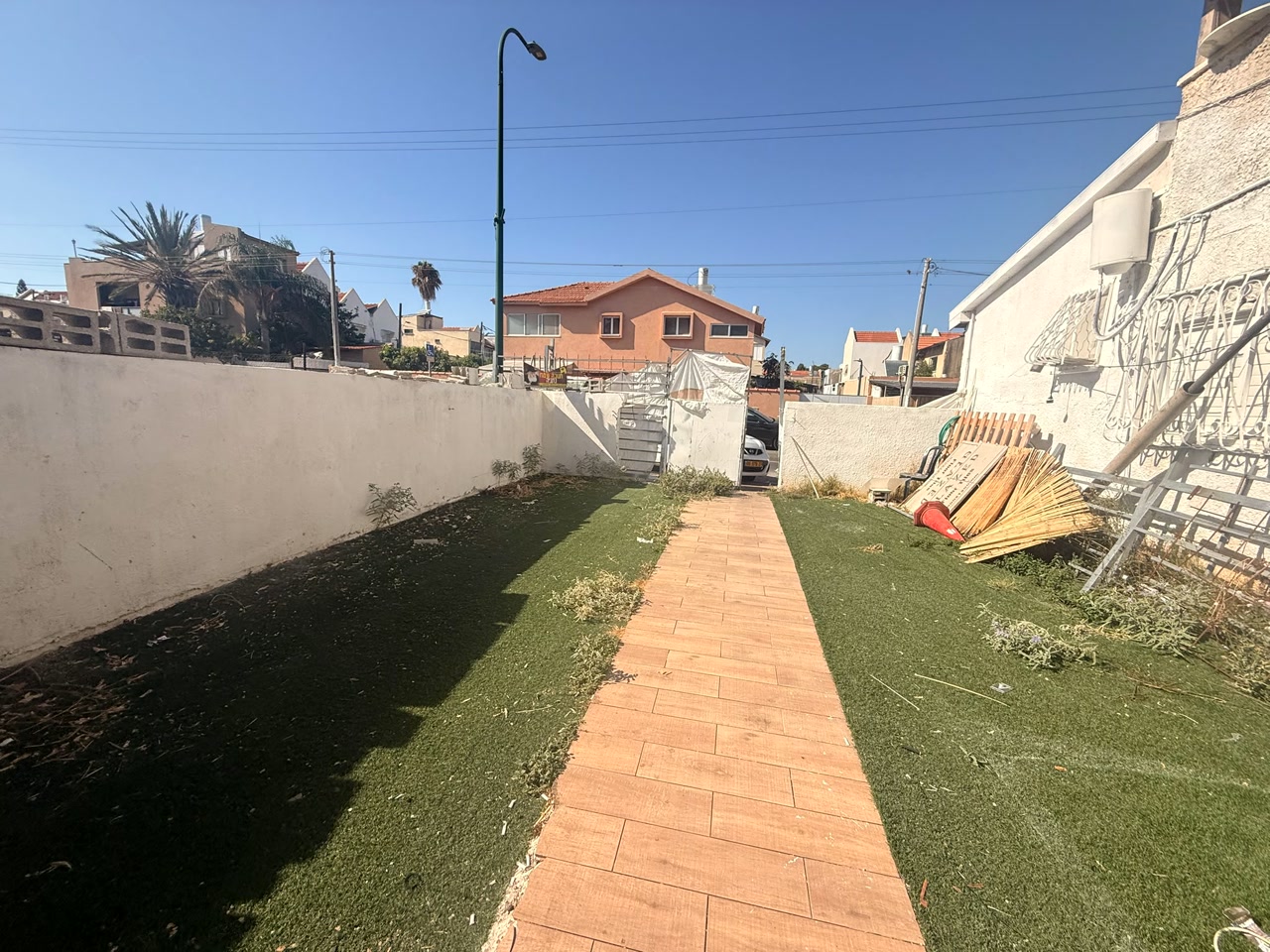 החצר הגדולה של הדירה - דשא ושביל מרוצף
